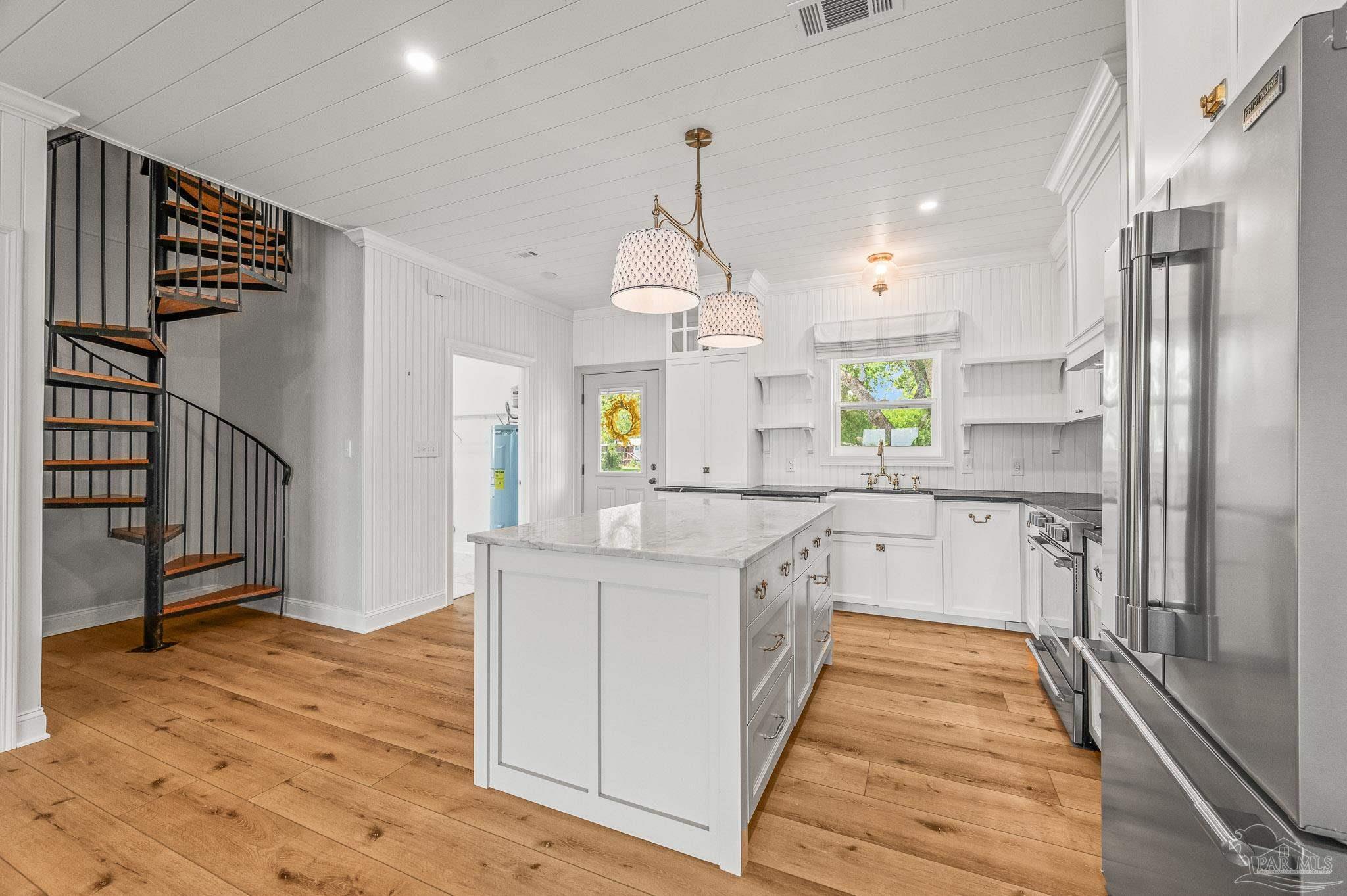 7693 Petersen Point Road Milton, FL 32583 - Photo 8 of 58 a large kitchen with stainless steel appliances granite countertop a refrigerator a oven a stove and a wooden floors