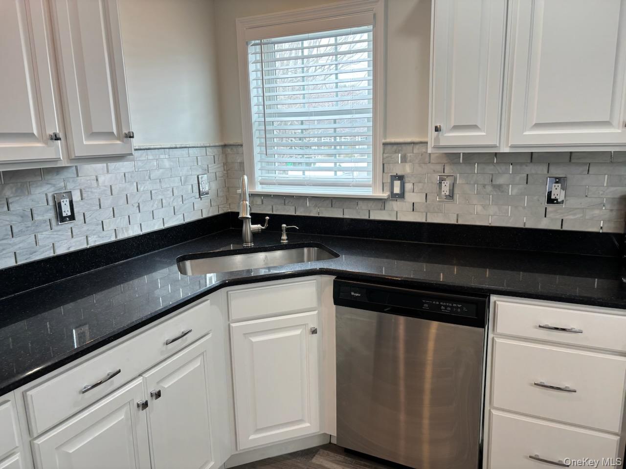 1661 Old Country Road, Unit 539 Riverhead, NY 11901 - Photo 17 of 26 a kitchen with granite countertop white cabinets and a black appliances