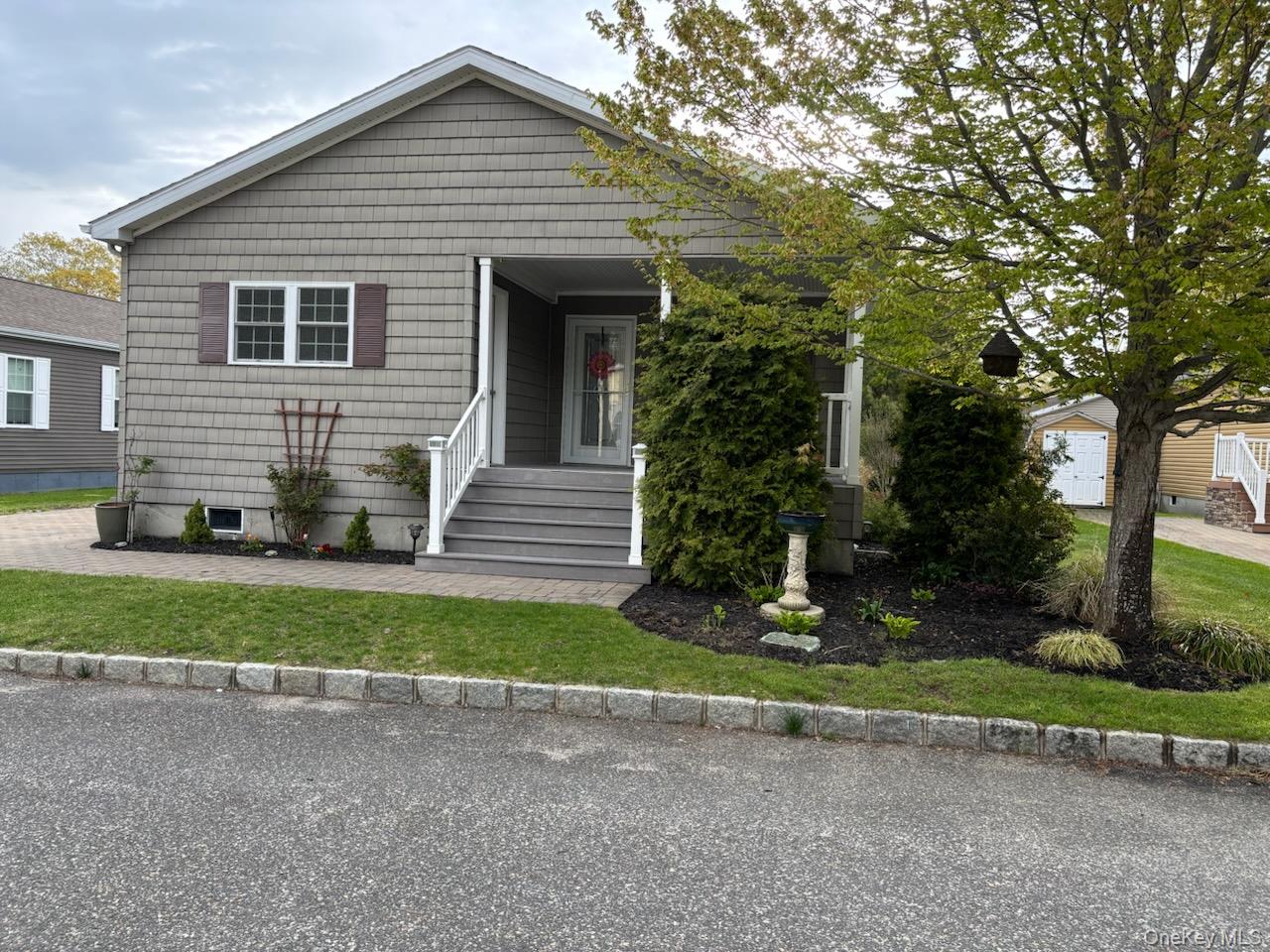 1661 Old Country Road, Unit 539 Riverhead, NY 11901 - Photo 2 of 26 a front view of a house with a yard and garage