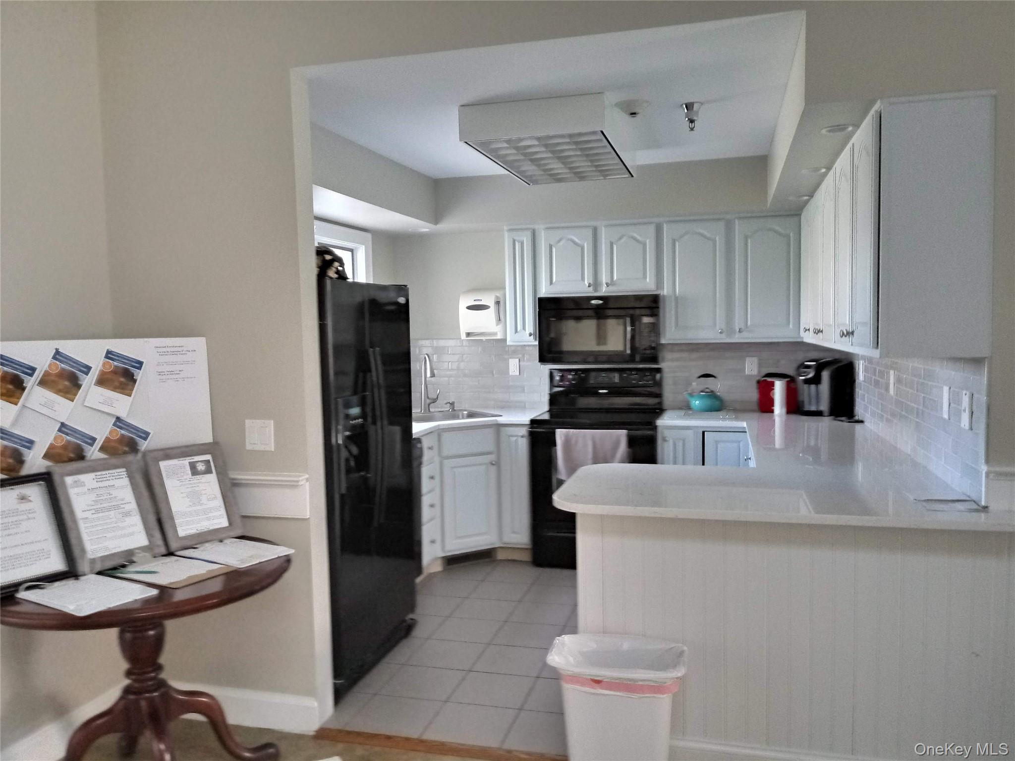 1661 Old Country Road, Unit 539 Riverhead, NY 11901 - Photo 24 of 26 a kitchen with a sink a stove and a refrigerator