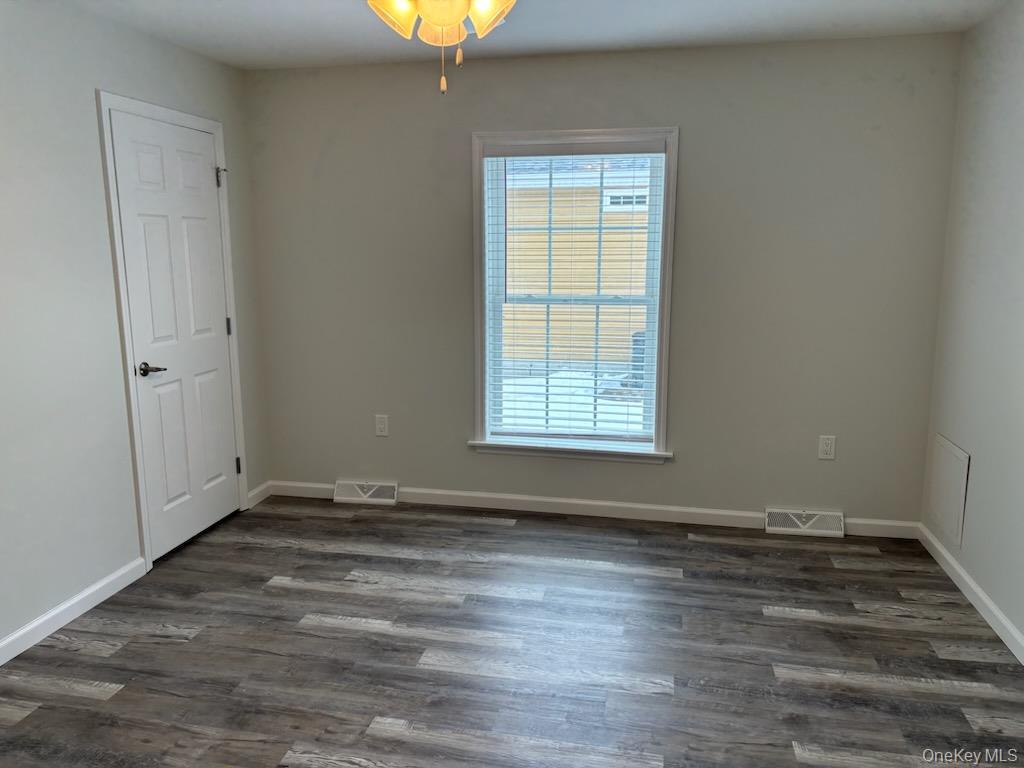 1661 Old Country Road, Unit 539 Riverhead, NY 11901 - Photo 9 of 26 an empty room with wooden floor and windows