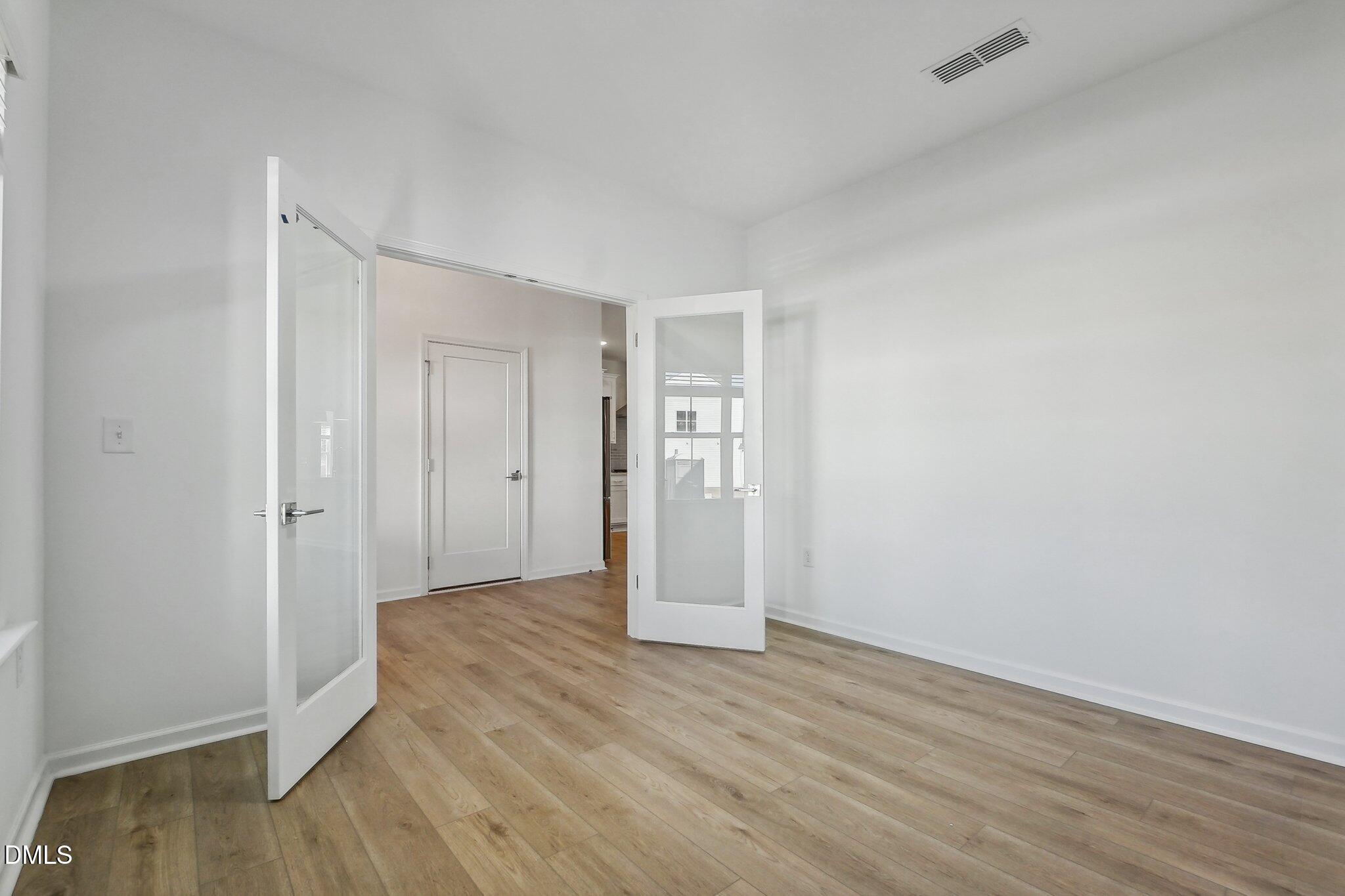 2209 Seraphic Way, Unit 402 Rolesville, NC 27571 - Photo 11 of 26 a view of an empty room with wooden floor