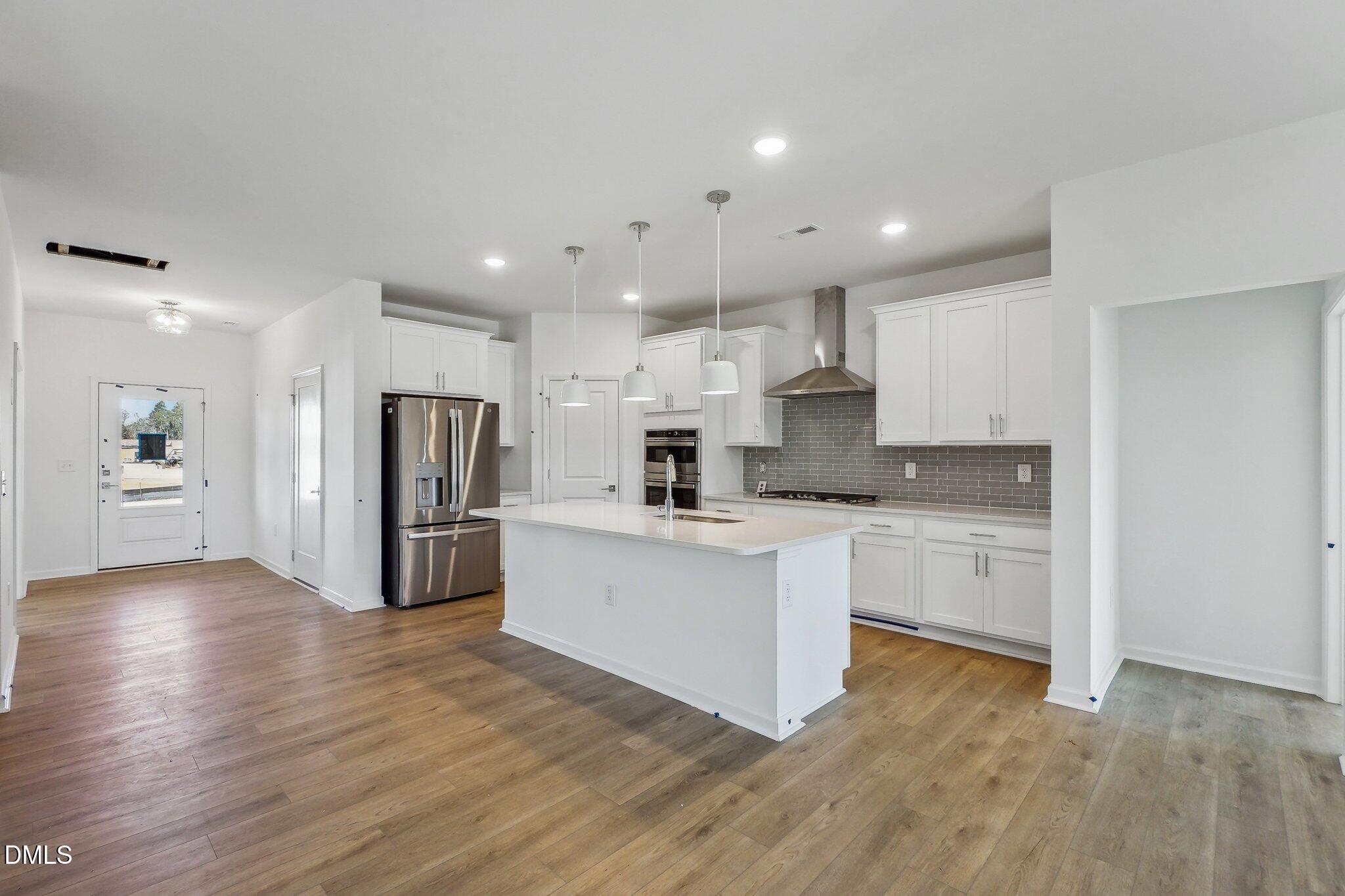 2209 Seraphic Way, Unit 402 Rolesville, NC 27571 - Photo 12 of 26 a kitchen with white cabinets and stainless steel appliances