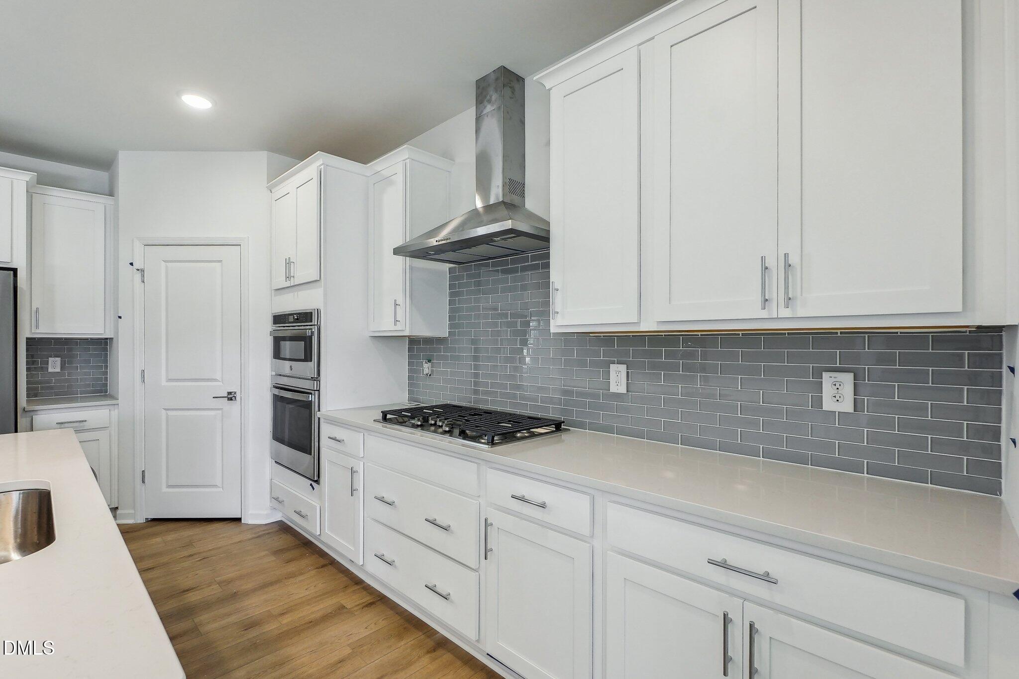 2209 Seraphic Way, Unit 402 Rolesville, NC 27571 - Photo 13 of 26 a kitchen with stainless steel appliances white cabinets and a stove