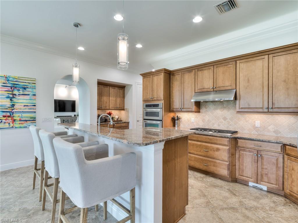 14468 Marsala Way Naples, FL 34109 - Photo 15 of 41 a kitchen with kitchen island granite countertop a sink and counter space