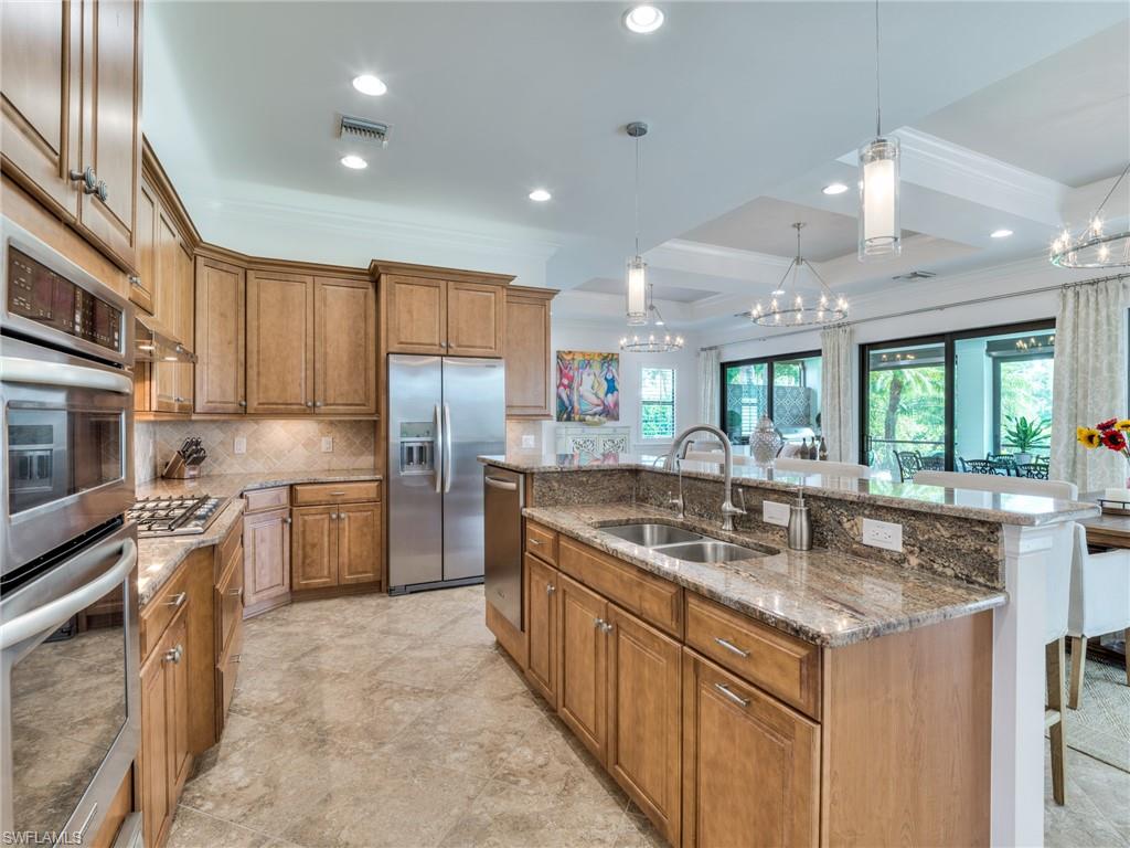 14468 Marsala Way Naples, FL 34109 - Photo 16 of 41 a kitchen with stainless steel appliances granite countertop a sink stove and refrigerator