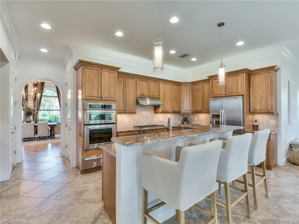 14468 Marsala Way Naples, FL 34109 - Photo 17 of 41 a kitchen with stainless steel appliances granite countertop a stove top oven a sink refrigerator and cabinets