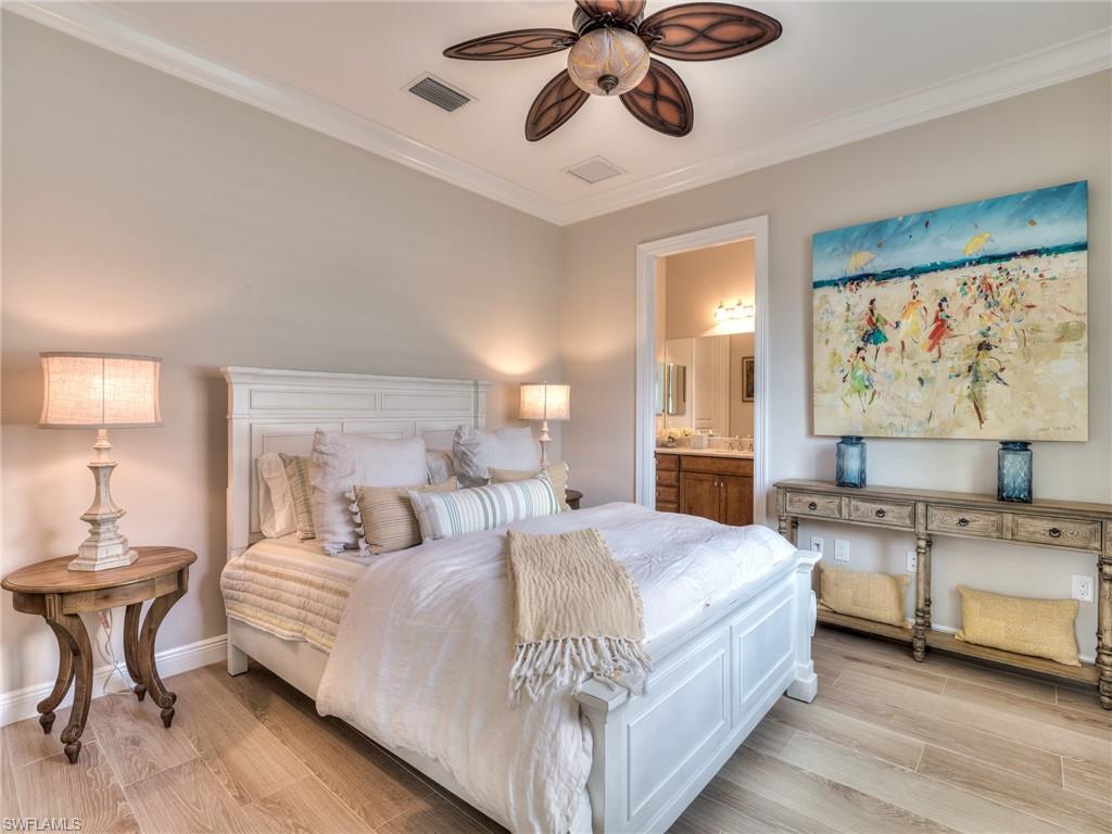 14468 Marsala Way Naples, FL 34109 - Photo 33 of 41 a bedroom with a large bed and a chandelier