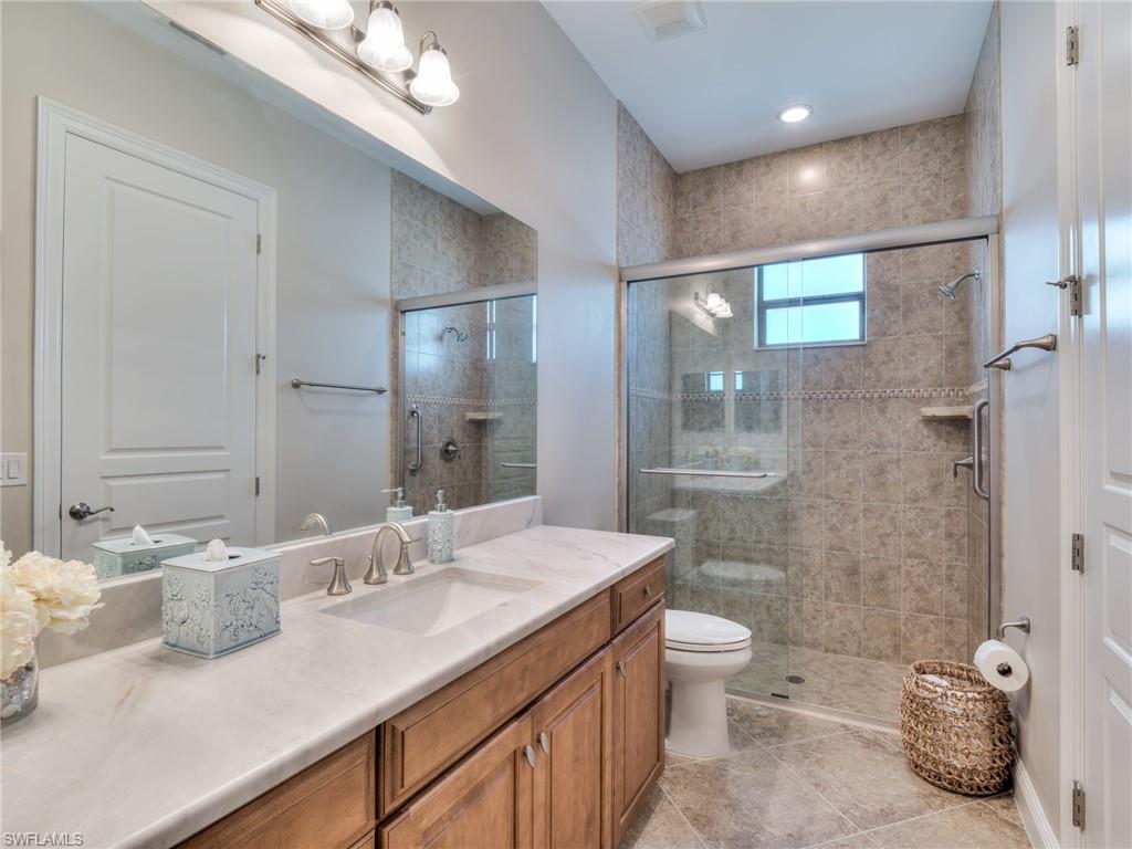 14468 Marsala Way Naples, FL 34109 - Photo 35 of 41 a bathroom with a granite countertop sink a toilet and shower