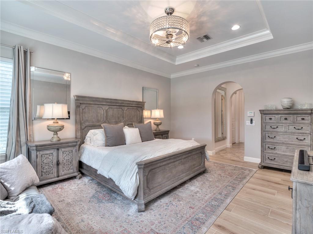 14468 Marsala Way Naples, FL 34109 - Photo 36 of 41 a bedroom with a large bed and chandelier