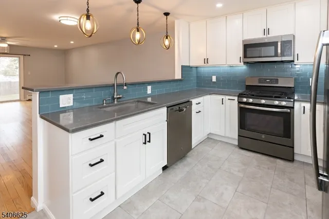 a kitchen with stainless steel appliances granite countertop a sink and a stove