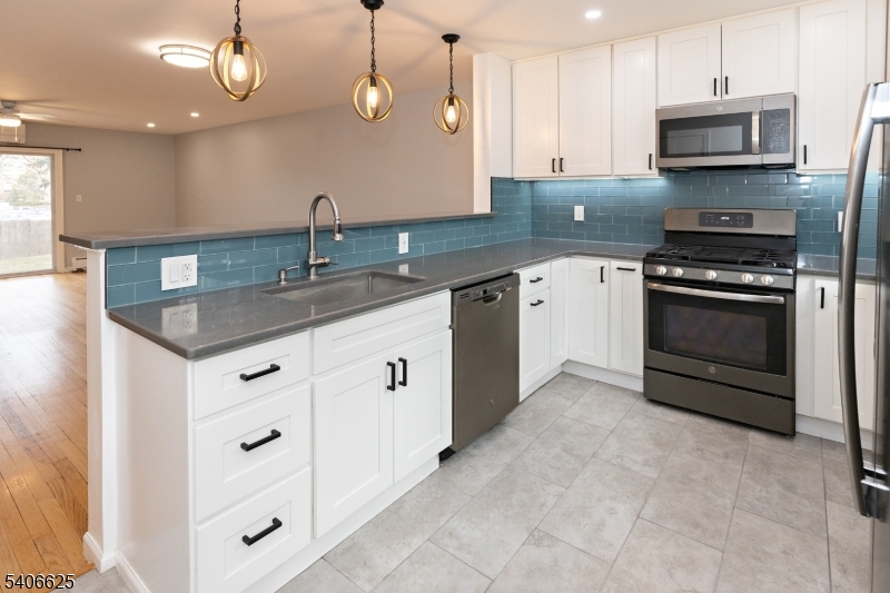 a kitchen with stainless steel appliances granite countertop a sink and a stove