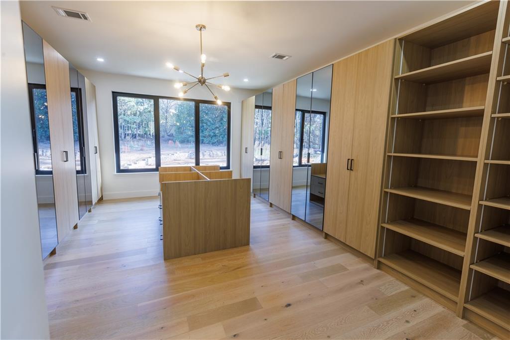 4805 Moore Road Suwanee, GA 30024 - Photo 101 of 119 a view of a hallway with wooden floor and cabinet