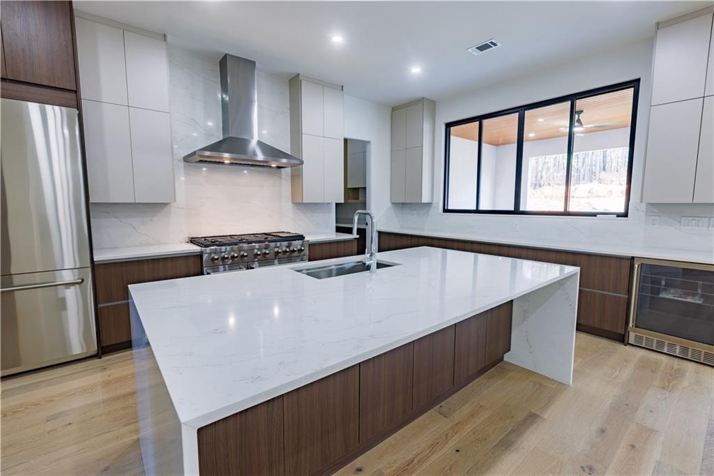 4805 Moore Road Suwanee, GA 30024 - Photo 51 of 119 a kitchen with stainless steel appliances a refrigerator a sink a stove a microwave and wooden floor