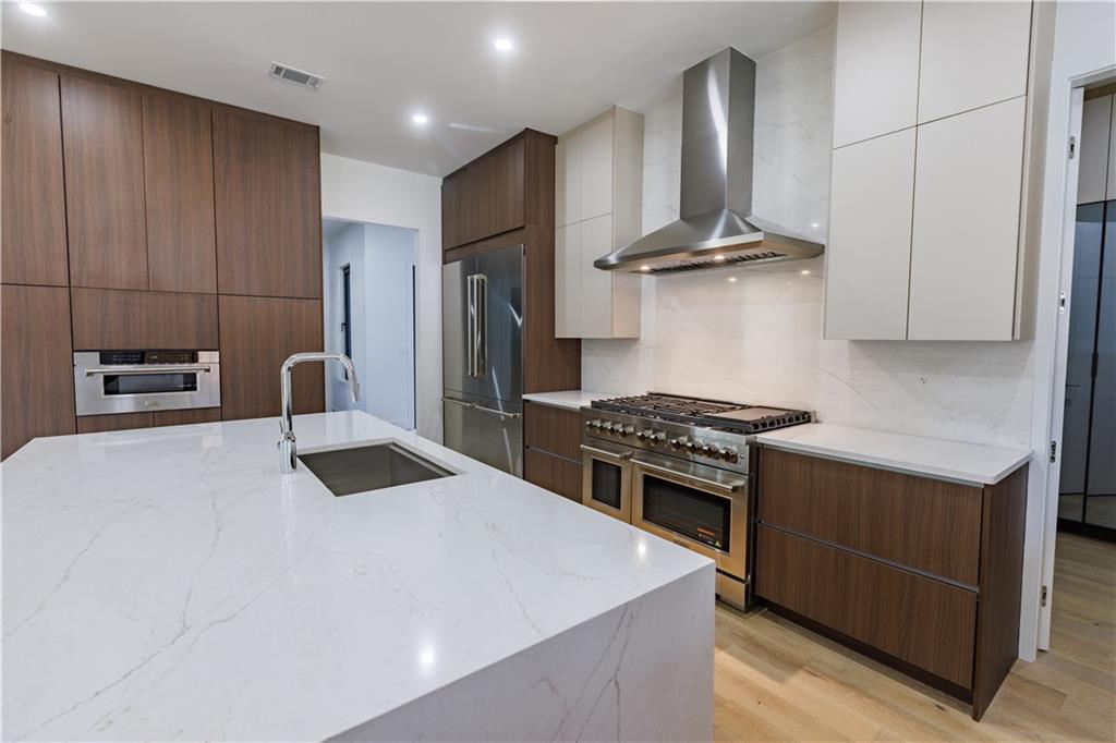 4805 Moore Road Suwanee, GA 30024 - Photo 53 of 119 a kitchen with stainless steel appliances a stove a refrigerator and a sink