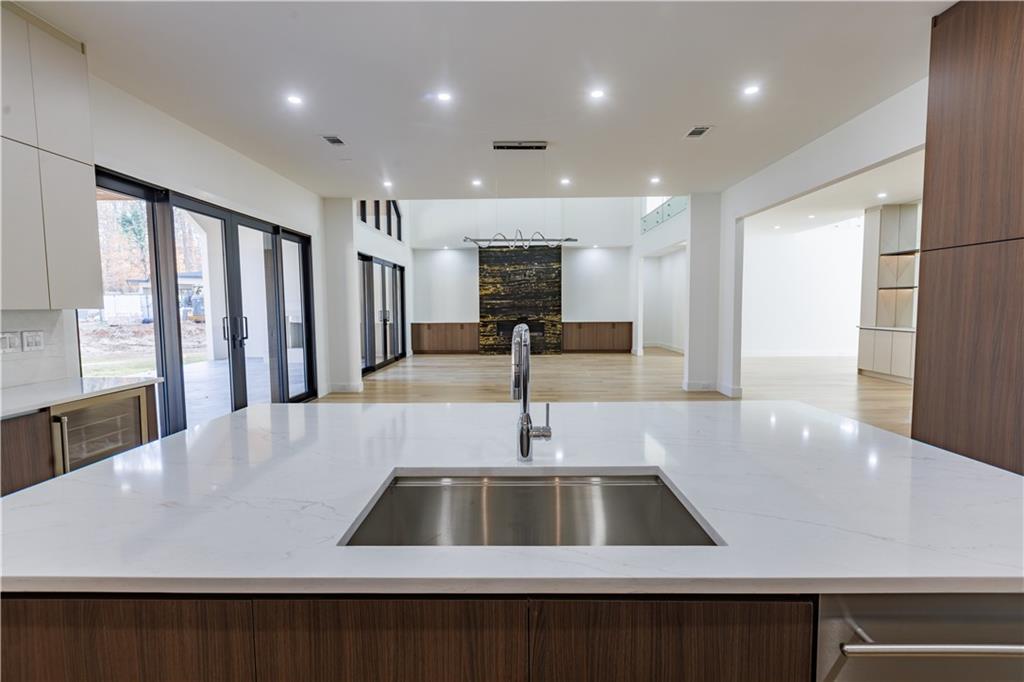 4805 Moore Road Suwanee, GA 30024 - Photo 54 of 119 a view with kitchen island a sink a counter top space and stainless steel appliances
