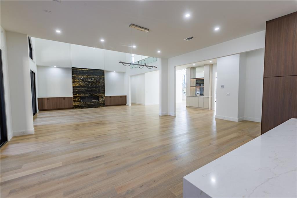 4805 Moore Road Suwanee, GA 30024 - Photo 55 of 119 a view of an empty room with wooden floor and a kitchen