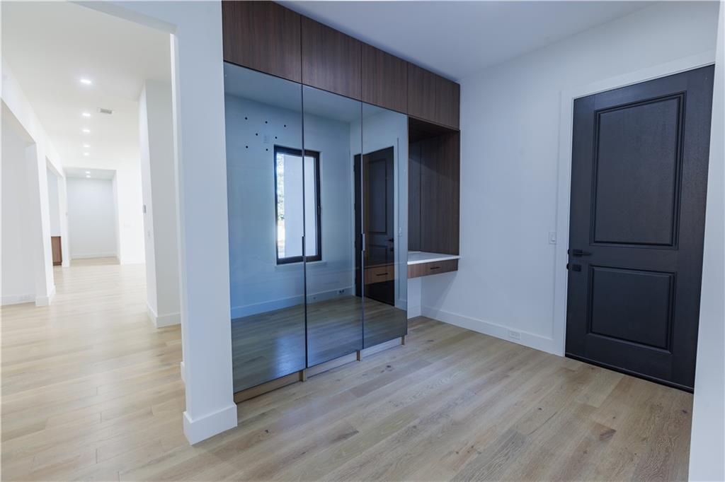 4805 Moore Road Suwanee, GA 30024 - Photo 57 of 119 an empty room with wooden floor and way to kitchen