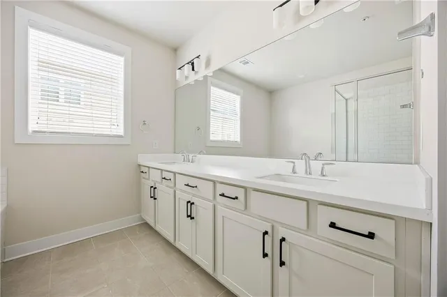 a bathroom with double sink and a window