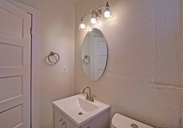 a bathroom with a toilet a sink and mirror