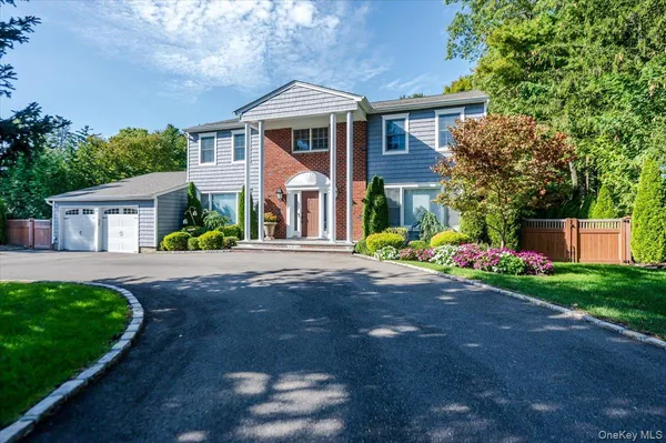 a front view of a house with a yard and garden