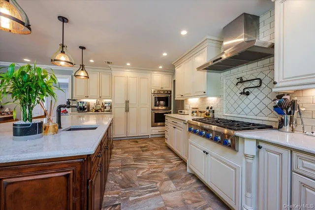 a kitchen with stainless steel appliances granite countertop a sink a stove and a wooden floors