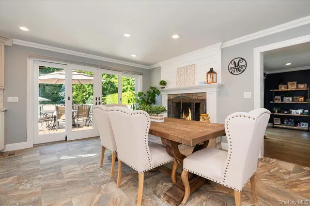 a dining room with furniture a fireplace and wooden floor