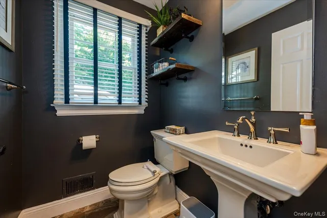 a bathroom with a sink a toilet and a mirror