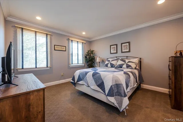 a spacious bedroom with a bed and a flat screen television