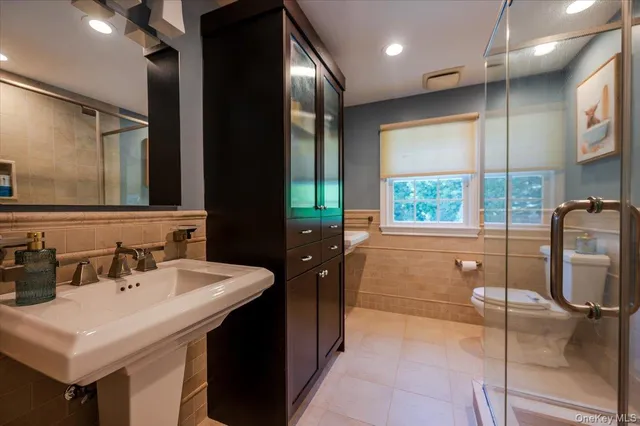 a bathroom with a sink a toilet and mirror