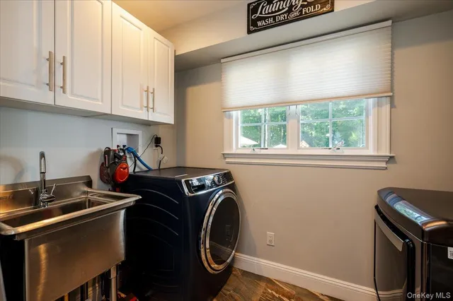 a utility room with dryer washer and a window