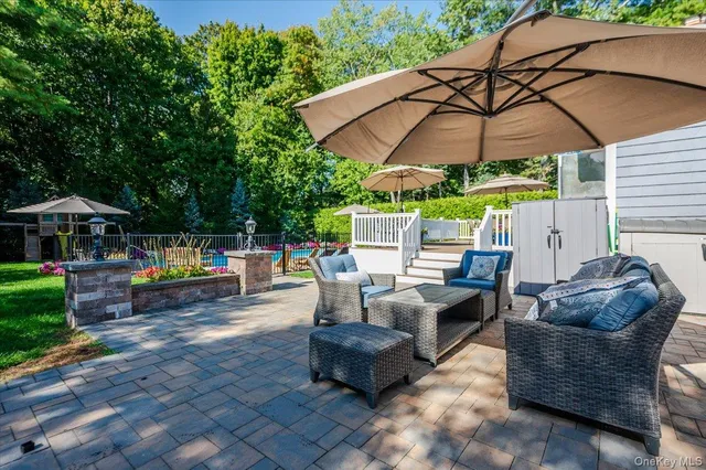 a view of a patio with a table and chairs under an umbrella