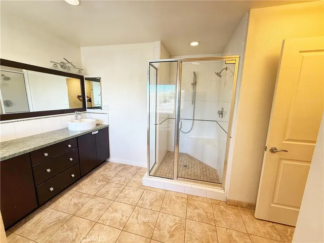 a bathroom with a glass shower sink and mirror