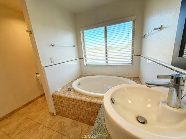 a bathroom with a tub a sink and a window