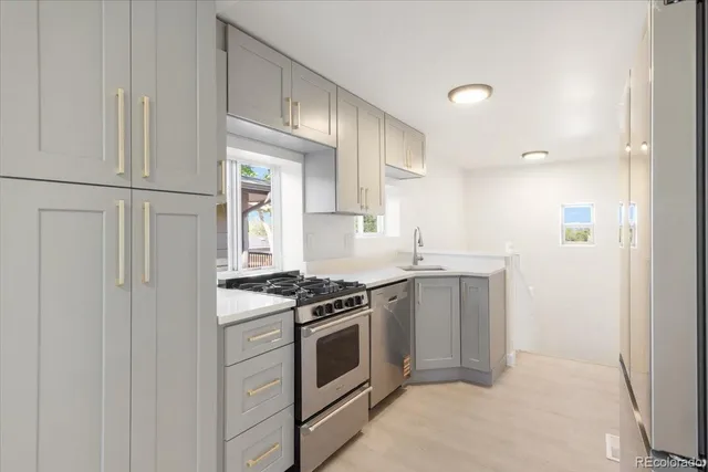 a kitchen with stainless steel appliances granite countertop white cabinets and a stove