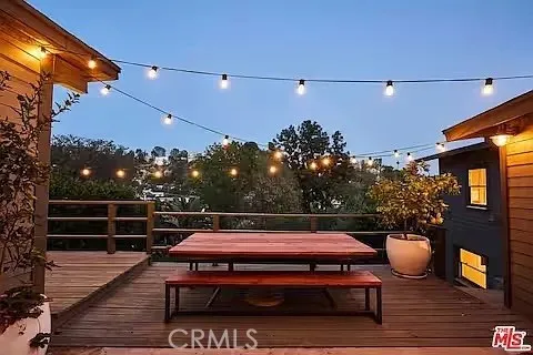 a view of a roof deck with table and chairs with wooden floor and fence