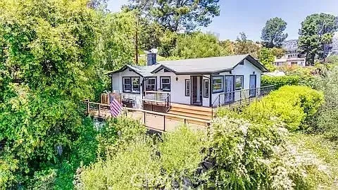 a view of a house with a big yard and large trees