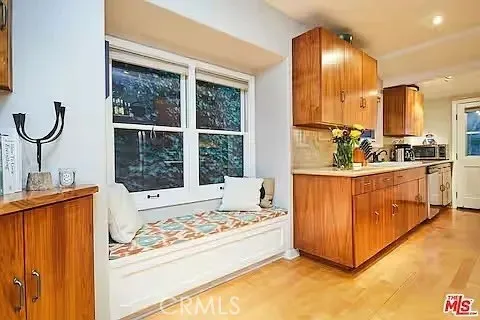 a view of a kitchen with kitchen island a large window and cabinets