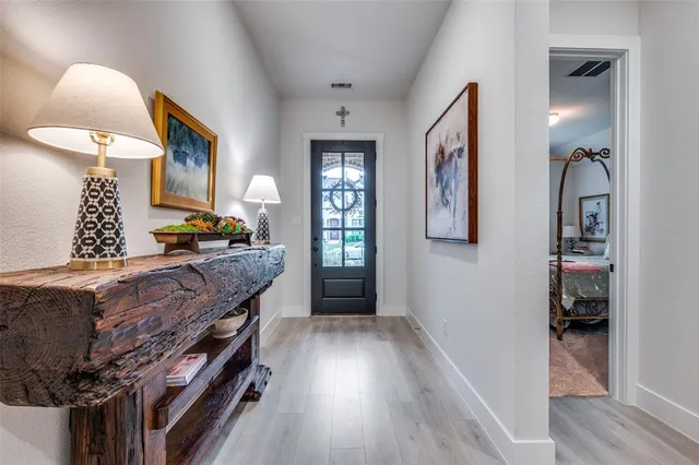 a hallway with a large mirror and cabinets