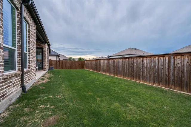 a view of a backyard with wooden fence