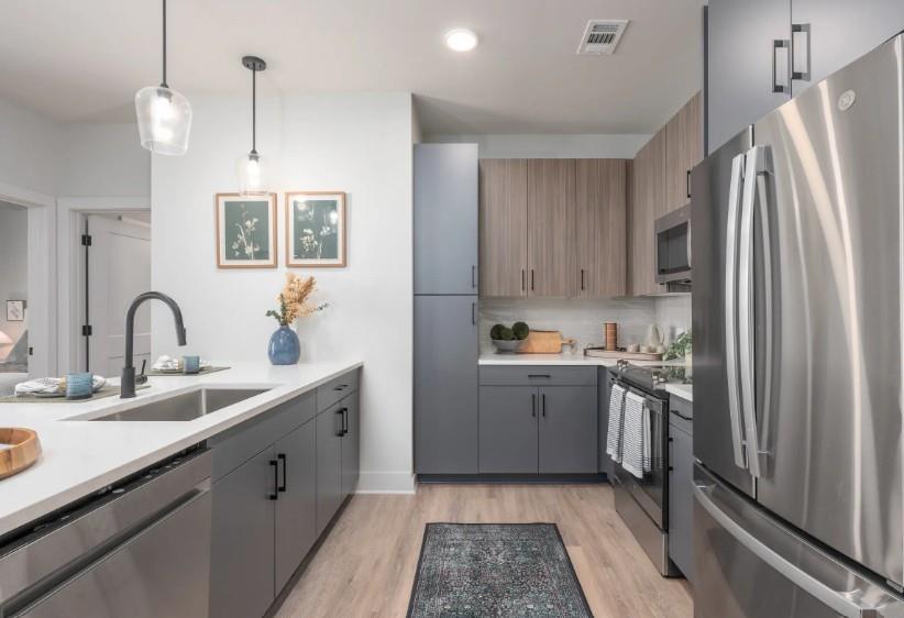 a kitchen with stainless steel appliances granite countertop a sink stove and refrigerator