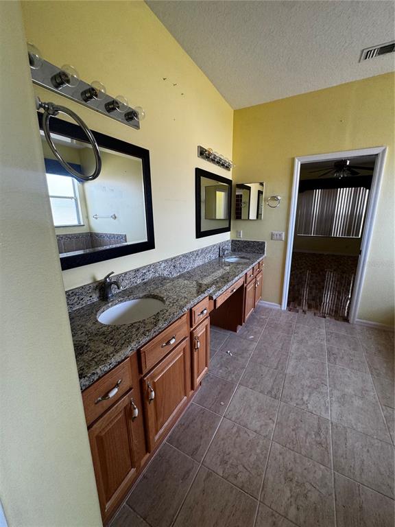 15296 Southwest 15th Terrace Road Ocala, FL 34473 - Photo 6 of 15 a en suite bathroom with a granite countertop sink and a mirror
