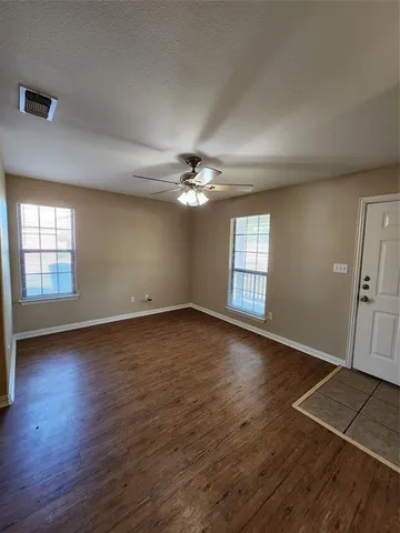 an empty room with wooden floor and window