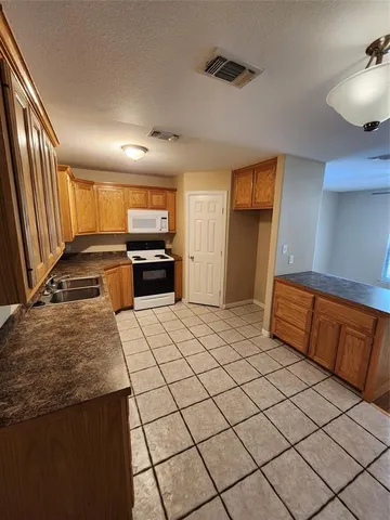 a large kitchen with a stove a sink dishwasher and a refrigerator