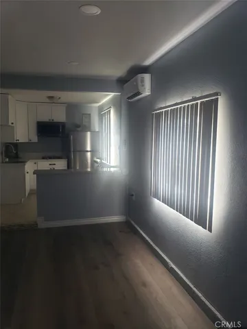 a view of a kitchen and an empty room with a window