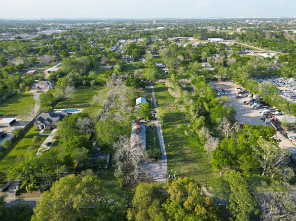 an aerial view of residential houses with outdoor space and trees