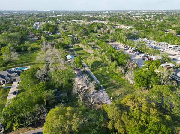 an aerial view of residential houses with outdoor space and trees