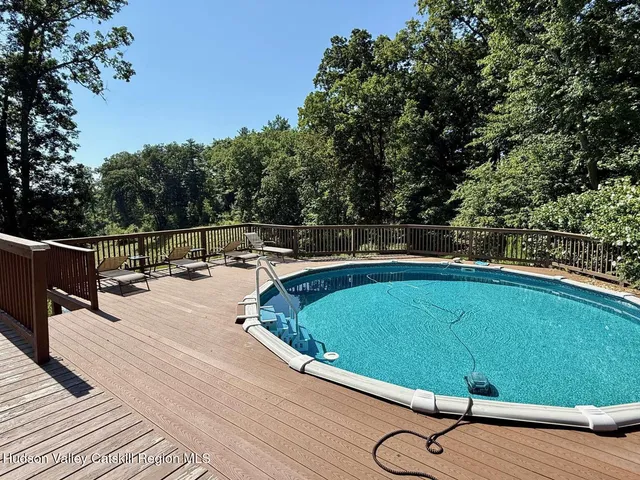 a view of a swimming pool with a lounge chair and floor to ceiling window