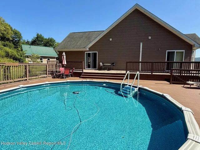 a view of house with swimming pool outdoor seating