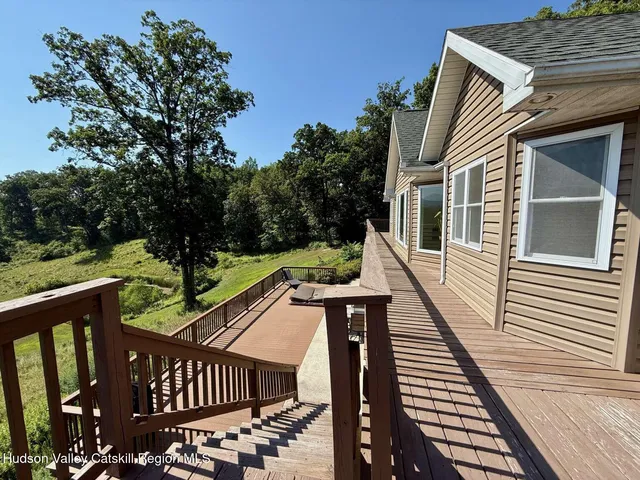 a view of a wooden deck with two chairs and a potted plant